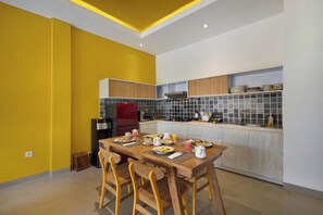 A modern kitchen with a dining area, equipped with a refrigerator, stove, and microwave. - La Mira Villa Seminyak by Ini Vie Hospitality (Kerobokan)