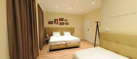 Une chambre d’hôtel avec un grand lit, un lit plus petit, une armoire, un bureau et une chaise.