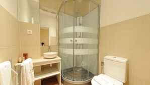A modern bathroom with a glass-enclosed shower, a white sink, and a toilet. - Naya - Downtown Guesthouse (Porto)