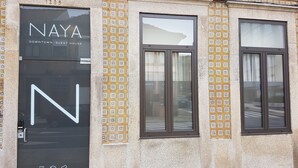 A building facade with a large 'N' sign, patterned tiles, and windows. - Naya - Downtown Guesthouse (Porto)