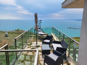 A balcony with outdoor furniture overlooking a body of water.