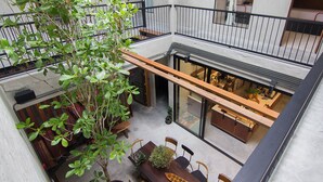 Um espaço interior com vários níveis, área de refeições, móveis de madeira e um vaso com planta.