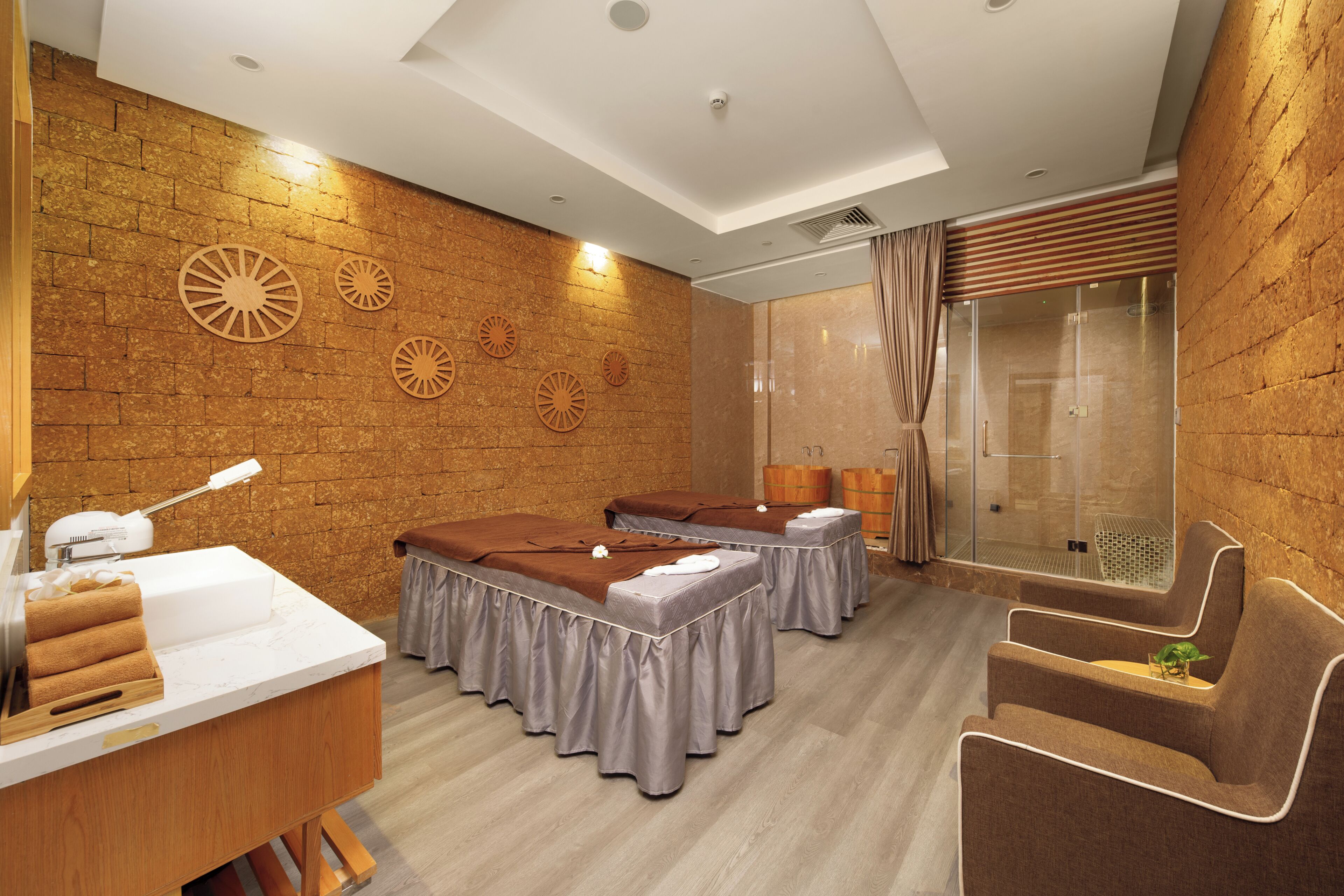 A spa room with two massage tables, a reception desk, and a shower area.