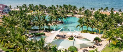 Una piscina al aire libre, sombrillas, tumbonas