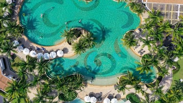 Una piscina al aire libre, sombrillas, tumbonas