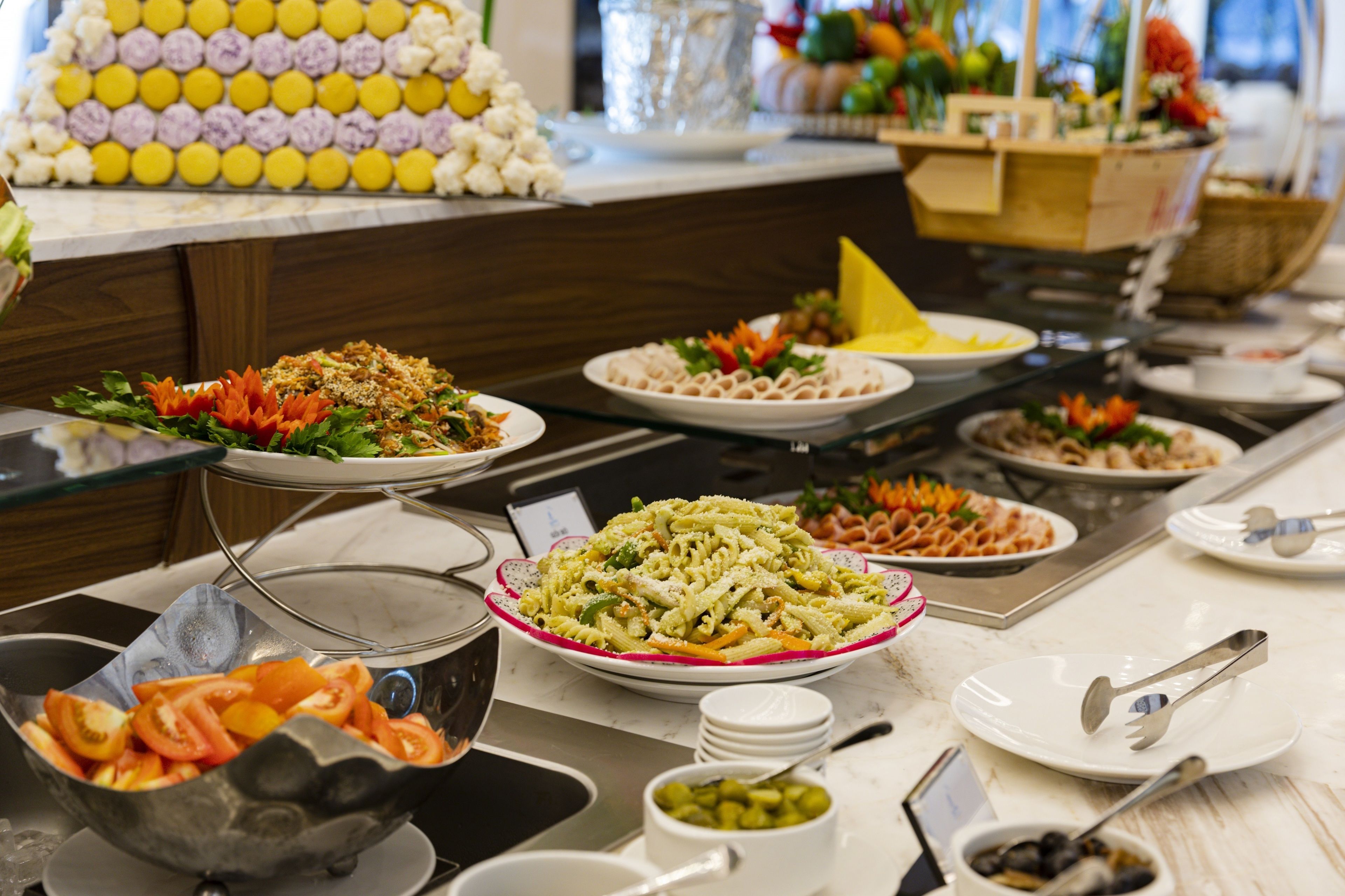 Un buffet proposant divers plats, notamment des pâtes, des salades et des légumes.