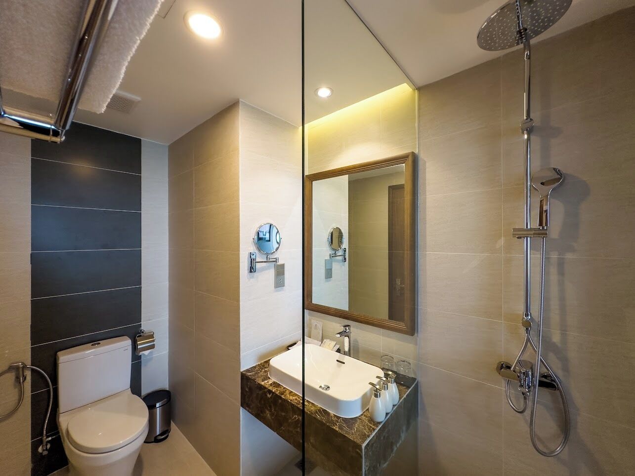 A modern bathroom with a toilet, sink, and shower.