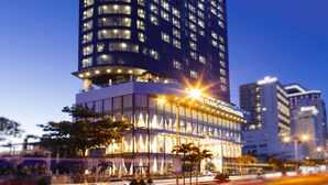A tall hotel with a modern design, featuring a prominent entrance and multiple floors. - Nha Trang Horizon Hotel (Bac Nha Trang)