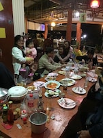 Un comedor con mesas dispuestas para varias personas, diferentes platos y condimentos.