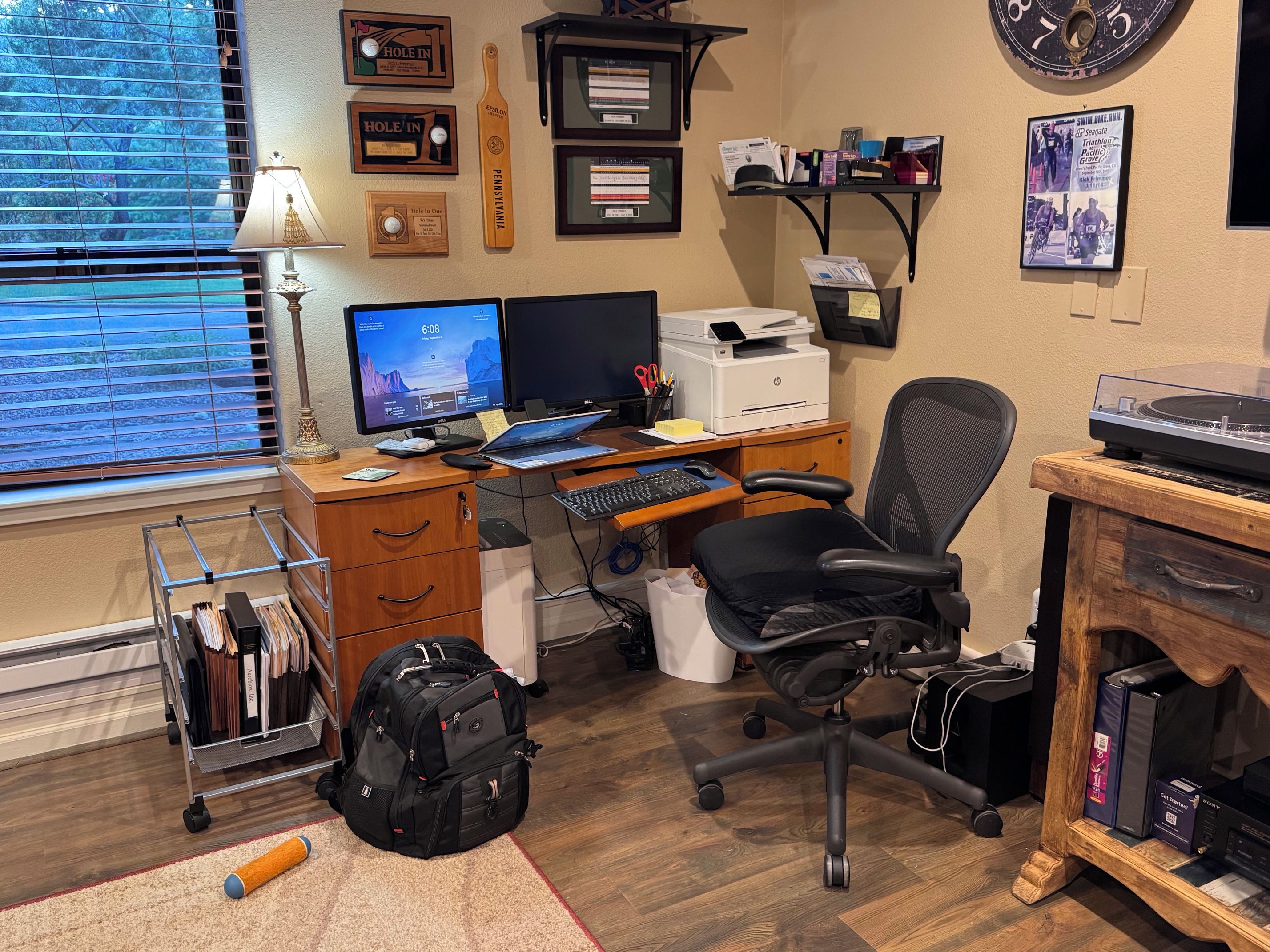 Ein Homeoffice mit Schreibtisch, Computer, Stuhl und verschiedenen persönlichen Gegenständen.