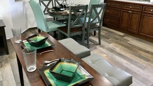 A dining area with a table set for four, surrounded by chairs, and a sofa. - Paradise Found,GREAT LOCATION,free golfcart, dishwasher, sup, kayak, rain water  (Spanish Wells)