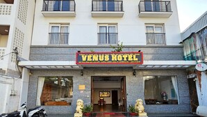 Ein Hotel mit einem Schild, auf dem 'Venus Hotel' und 'Lounge Hotel Massage' steht.
