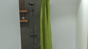 Ein modernes Badezimmer mit Dusche, Toilette und einem grünen Duschvorhang.