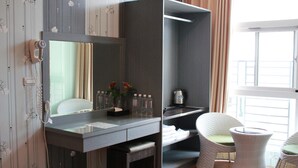 A modern bathroom with a large mirror, a vanity with a sink, and a chair. - JU Meet up with ocean (Hengchun)