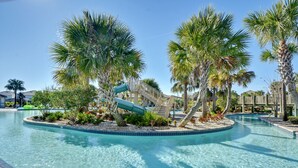 A swimming pool with a water slide, surrounded by palm trees and a wooden deck. - ChampionsGate, 9 Bed Superb Luxury Villa, Sleeps 34, South Facing Pool/Spa. (ChampionsGate)