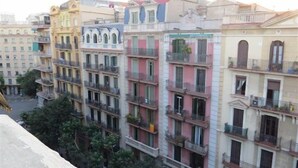 Un edificio a più piani con balconi e un cortile centrale.