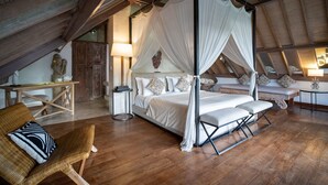 A bedroom with a four-poster canopy bed, wooden flooring, and a rustic ceiling. - Abaca Villas (Seminyak)