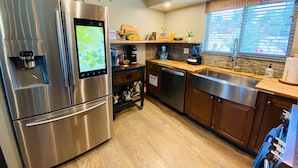 Una cocina moderna con electrodomésticos de acero inoxidable, un dispensador de agua integrado y un reloj digital.