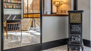 A room with a bookshelf, a lamp, a chair, and a decorative cabinet. - Albergo Etico Roma (Rome)