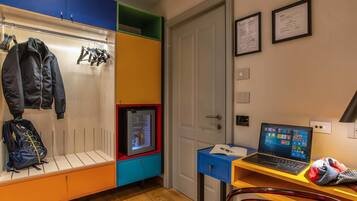 A room with a wardrobe, a laptop on a desk, and a door.