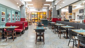 A restaurant interior with booths, tables, and a bar area. - Albergo Etico Roma (Rome)