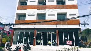 A multi-story building with a white facade and wooden accents. - Sleep Inn (Koh Samui)