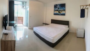 A hotel room with a bed, a desk with a computer, a chair, and a small table. - Sleep Inn (Koh Samui)