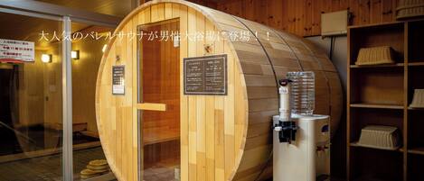 A wooden sauna with a glass door, a water dispenser, and wooden shelves with baskets.