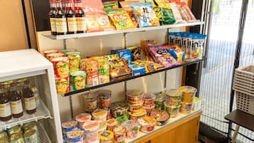 Diversos produtos embalados e bebidas em prateleiras e seção refrigerada.