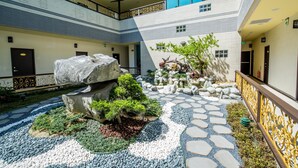 A courtyard with a rock garden, stepping stones, and a small tree. - Dongdaemun Boutique Hotel (Hualien City)
