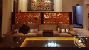 A modern living room with a sofa, a coffee table, and a large painting on the wall. - Dongdaemun Boutique Hotel (Hualien City)