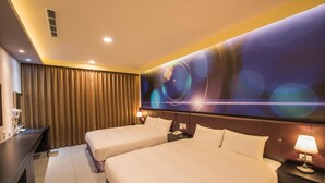A hotel room with two beds, a desk, a lamp, and a large abstract wall mural. - Dongdaemun Boutique Hotel (Hualien City)