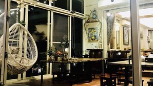 Un interior acogedor con una zona de comedor, adornos colgantes y un ventanal grande.