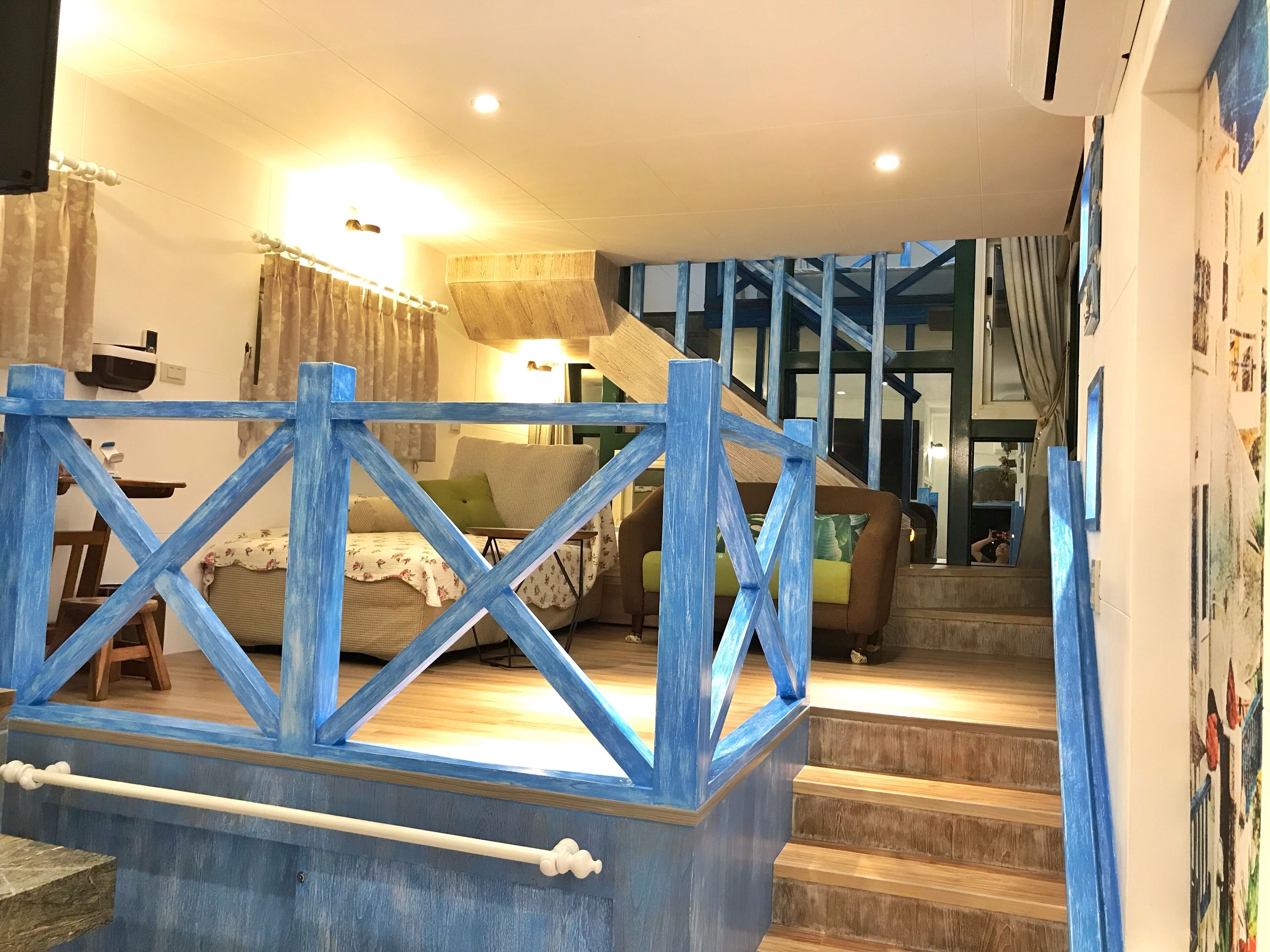 A staircase with blue railings leading to a living area with a sofa and a coffee table.