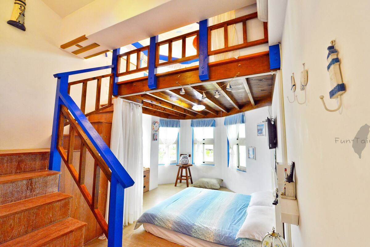 Um quarto com cama de solteiro, escada de madeira e um pequeno banquinho.