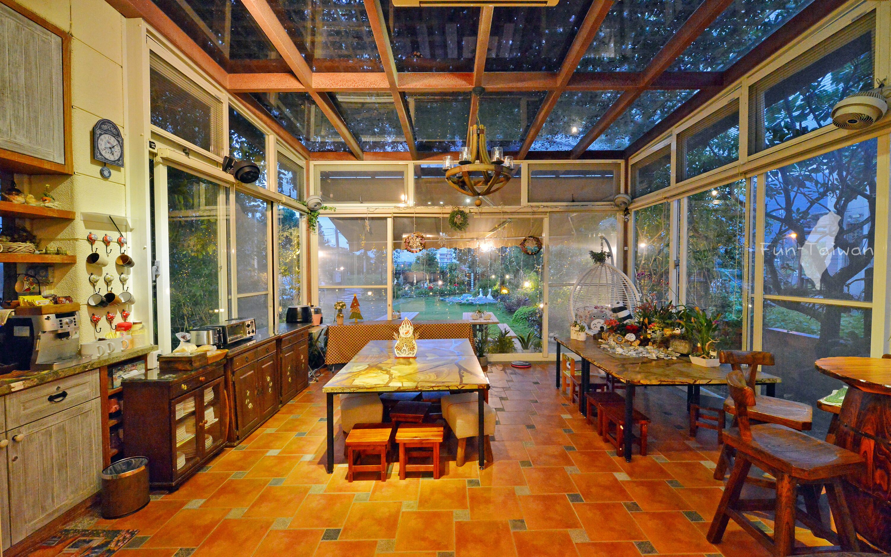 Una cocina amplia con un gran comedor, armarios de madera y vistas al jardín a través de amplios ventanales.