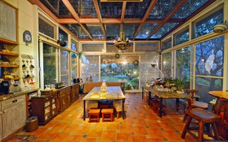 Una cocina amplia con un gran comedor, armarios de madera y vistas al jardín a través de amplios ventanales.