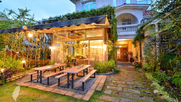 Un restaurante con mesas al aire libre, un espacio cubierto para comer y vista a un edificio al fondo.