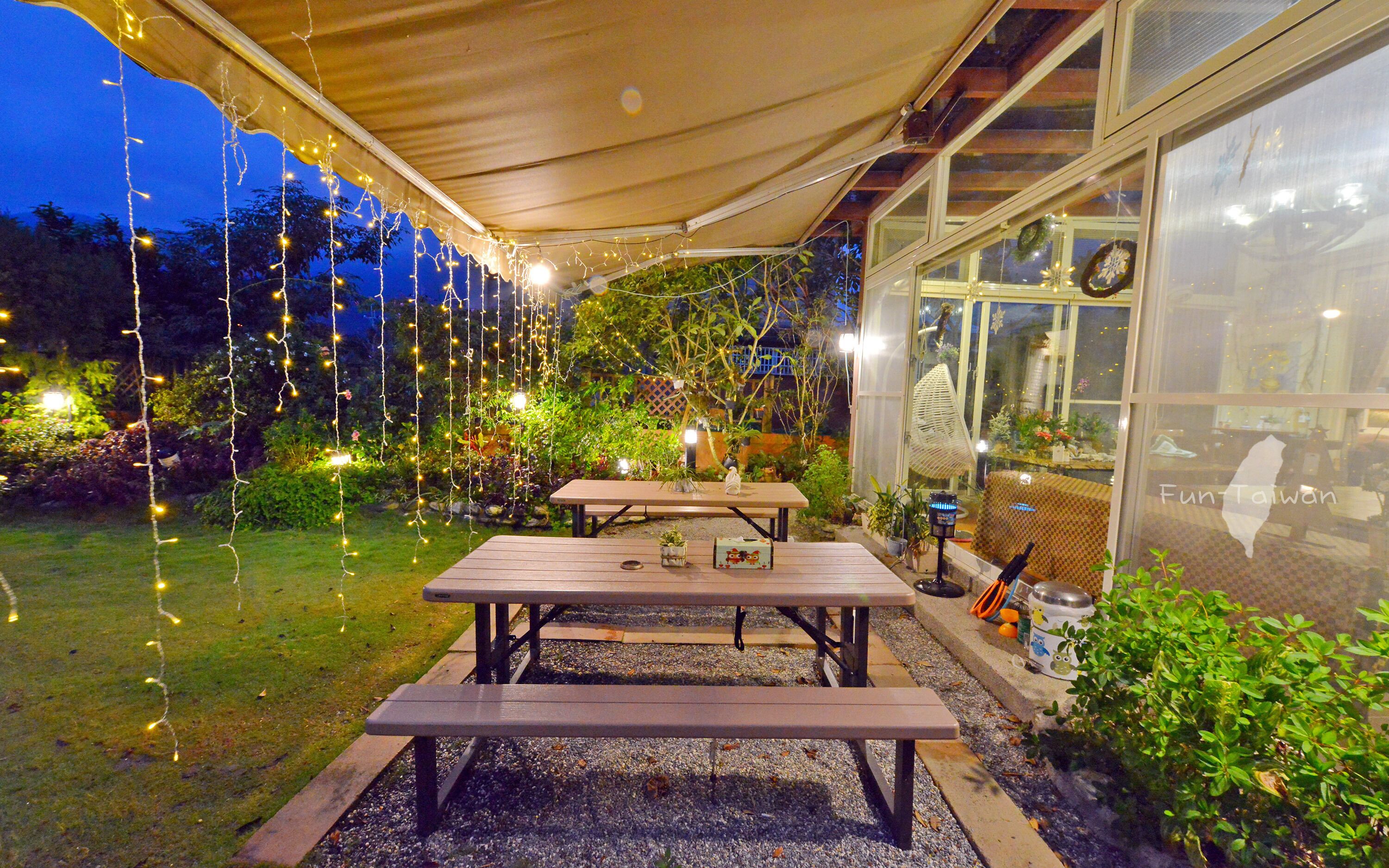 An outdoor patio area with picnic tables and string lights.