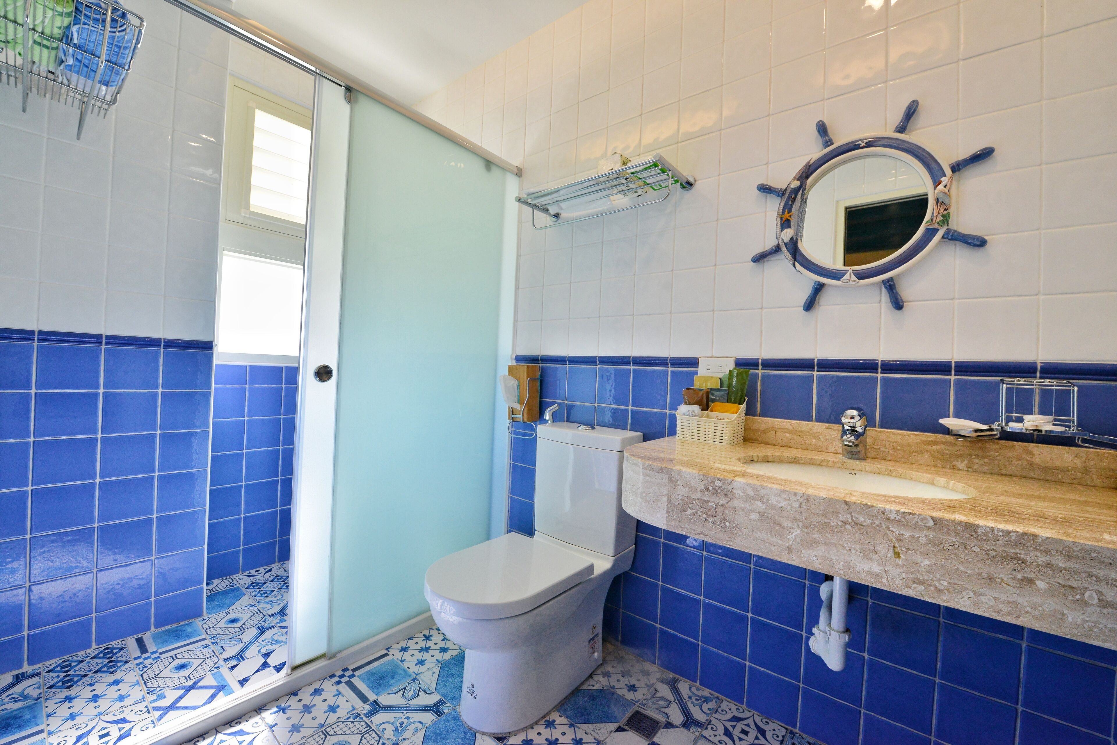 A bathroom with a toilet, sink, and mirror.