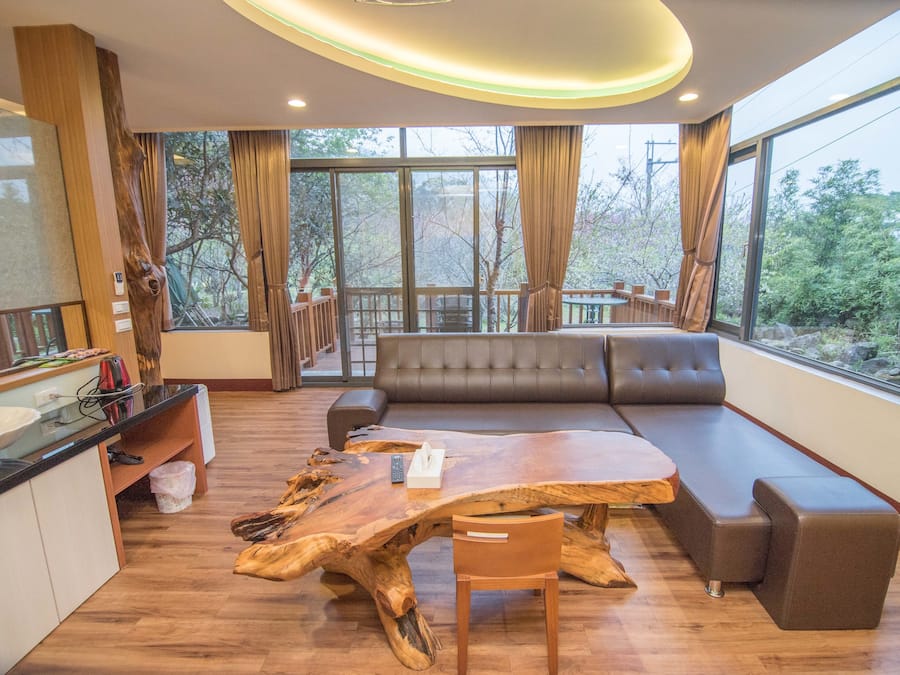 Una sala moderna con una gran mesa de centro de madera, un sofá y un comedor con mostrador de cocina.