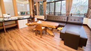 Un salon moderne avec une table à manger en bois, un canapé et un coin cuisine équipé d’un évier et de placards.