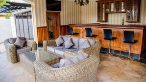 A wicker lounge area with a bar and seating. - Roma Gardens (Lusaka)