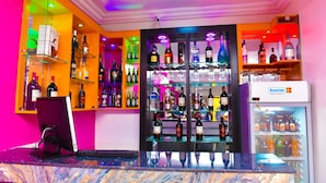A bar area with shelves of various liquor bottles, a computer monitor, and a Scanrot branded refrigerator. - Somerset Suites (Lagos)