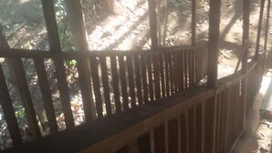 A wooden structure with a sloped roof, likely a covered outdoor area or veranda.