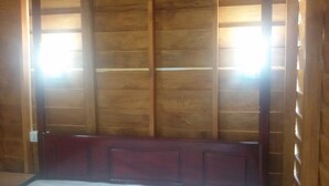 A room with wooden panel walls, a wooden bench, and a door with a window.