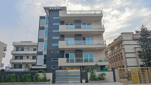 A multi-story residential building with balconies, a gated entrance, and a number sign. - Treebo Trip Vikrant's Residency (Gurugram)