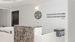 A reception desk with a clock and a sign stating "Outside food strictly not allowed, visitors not allowed inside the room." - Treebo Trip Vikrant's Residency (Gurugram)