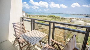 A balcony with wooden furniture and a view of the sea. - The Laid-back Dragon Lodge (Magong)