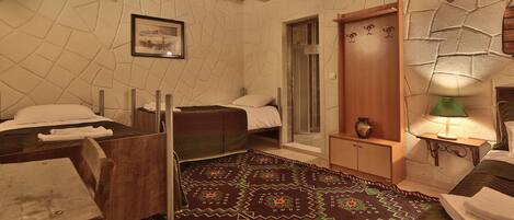 Una habitación acogedora con una cama, una mesa de madera, un banco y una alfombra estampada.